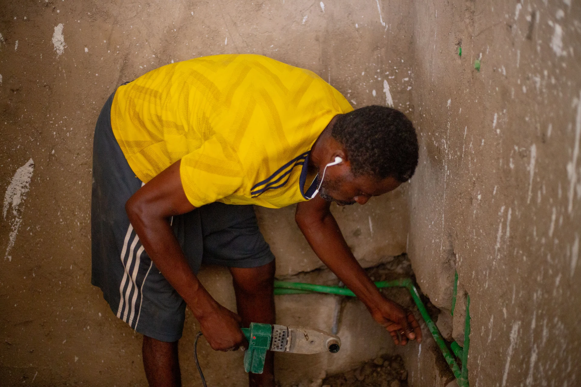 Qualified plumber in North Wales fixing a water connection in an apartment